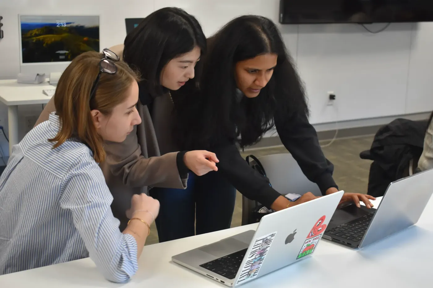 Three designers working together over a laptop