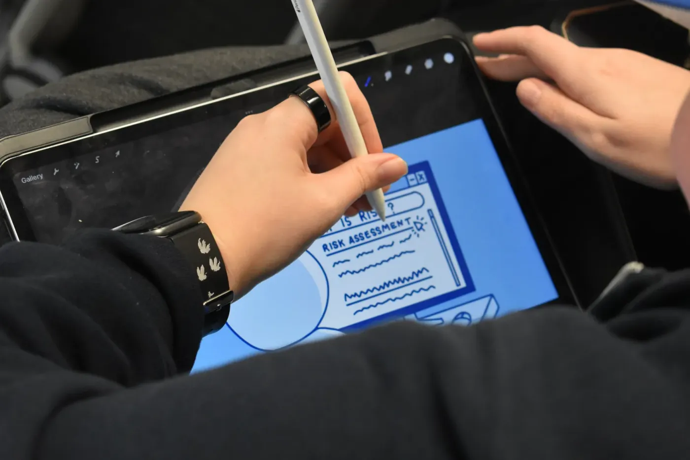 A hand sketching the risk assessment tool on a tablet