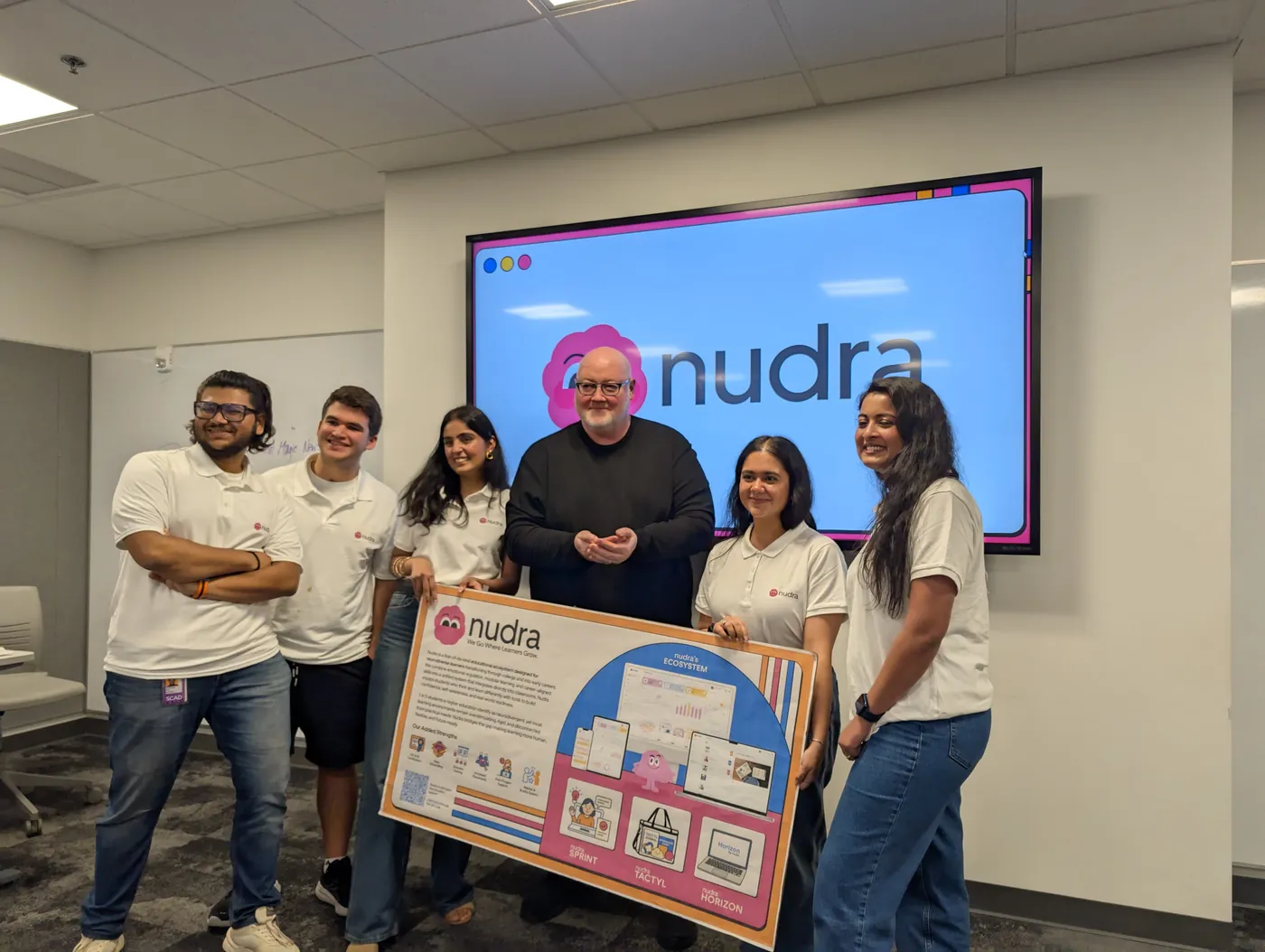 Team Comet with Professor John Storey holding the Nudra poster in front of the Nudra slide