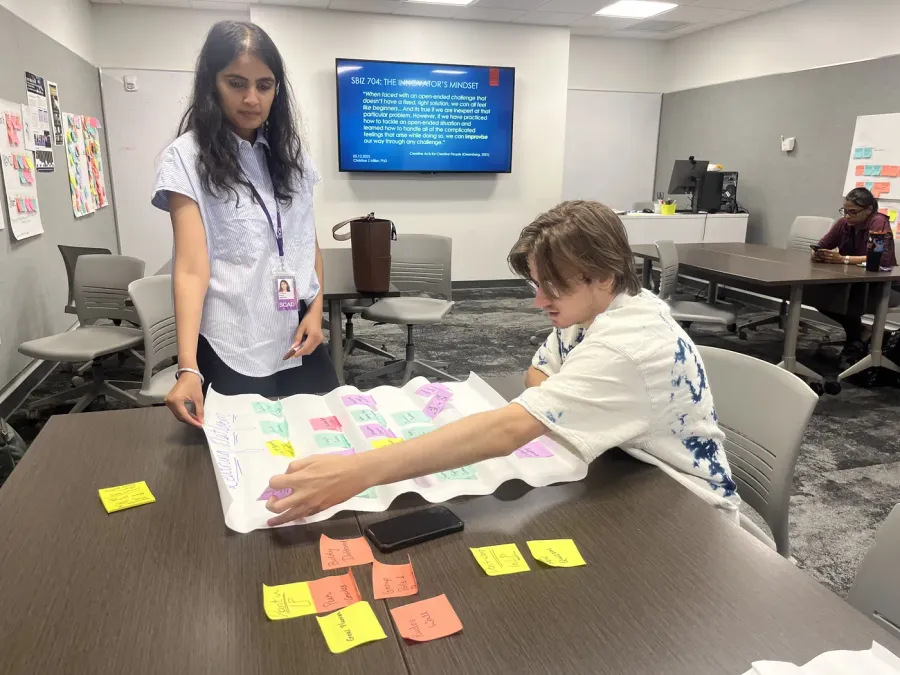 A participant mapping reactions on sticky notes next to the Tactyl kit